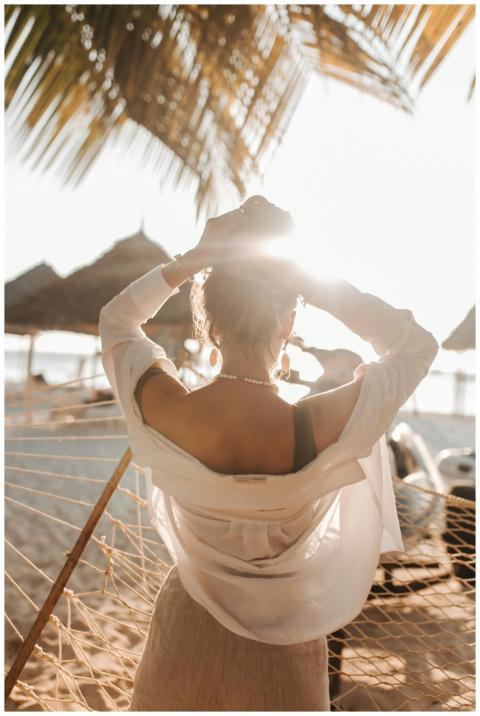 Woman enjoying the sun on a tropical beach in a ha