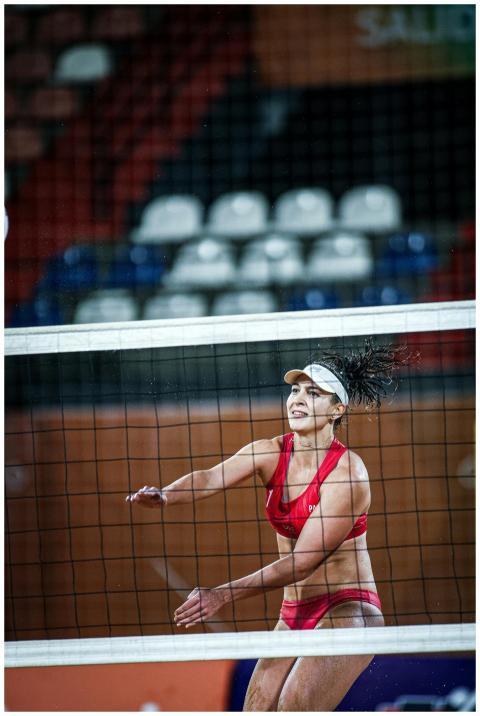 Female athlete playing beach volleyball, captured