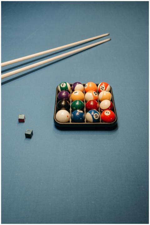 Vibrant billiard ball set with cue sticks on a blu