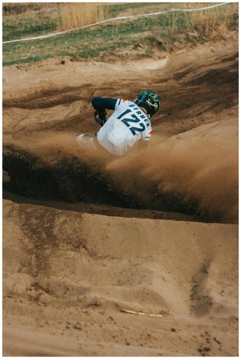 Dynamic shot of a motocross rider kicking up sand