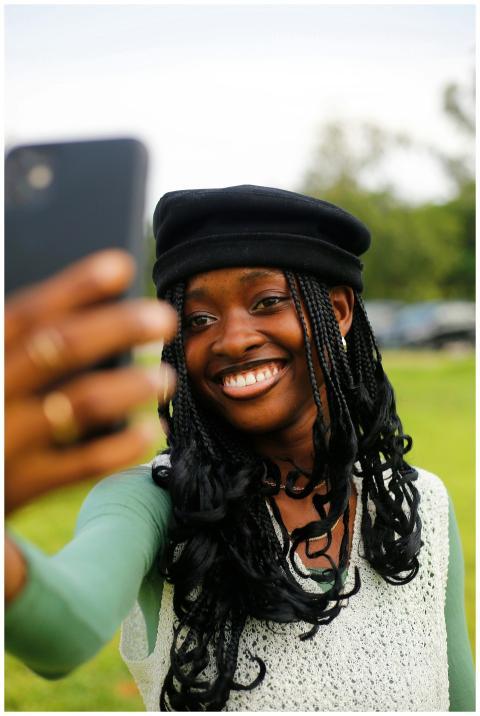 Smiling young woman in Abuja capturing a selfie wi
