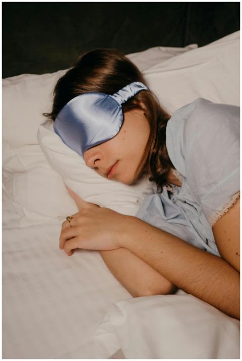 A woman peacefully sleeping with a satin eye mask,