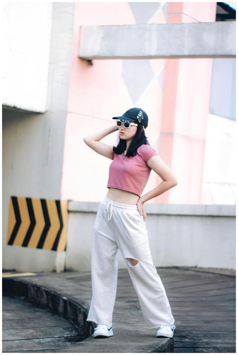 Trendy woman wearing a cap and crop top in an urba
