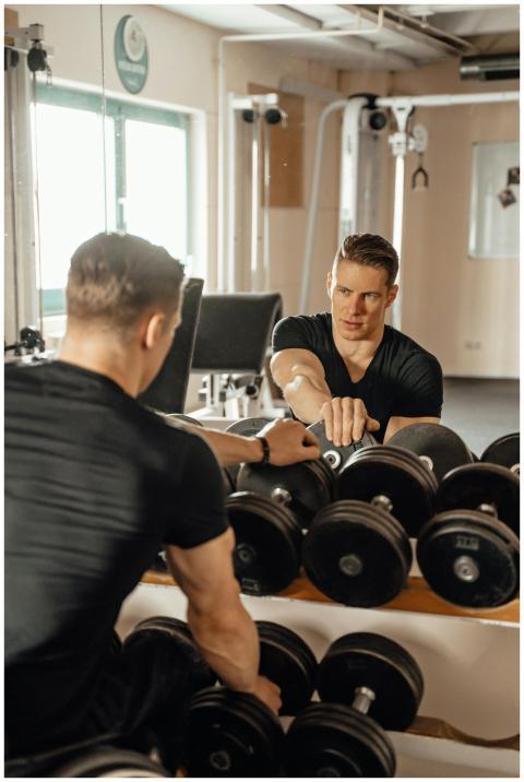 A man engages in weightlifting exercise at a gym,