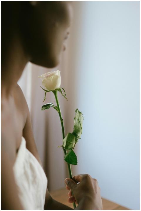 A serene moment of a woman holding a white rose, s