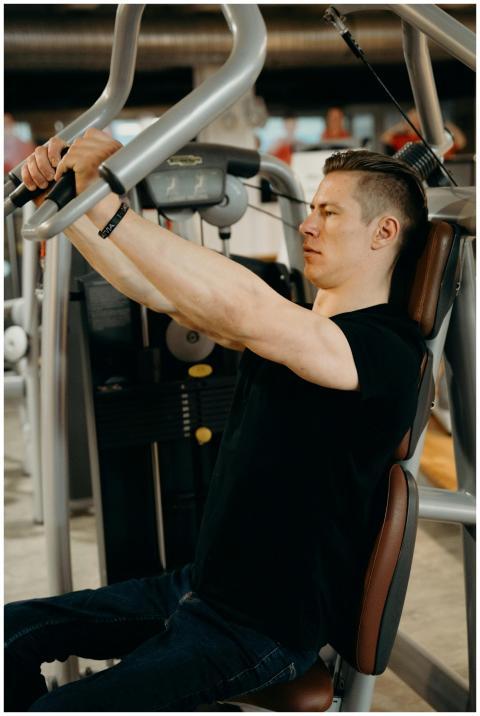 Adult man working out on a gym machine with focuse