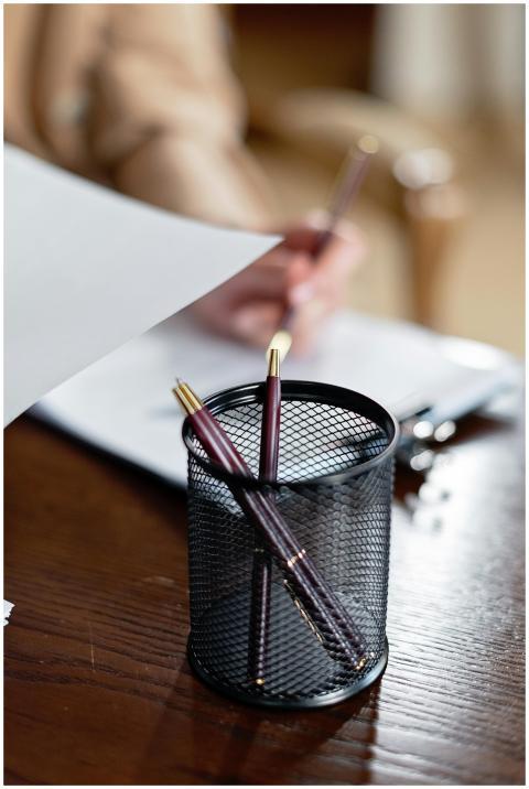 Close-up of an office desk with pens, paper, and a