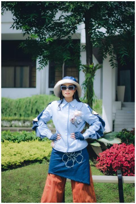 Fashionable woman posing in a vibrant garden in Ba