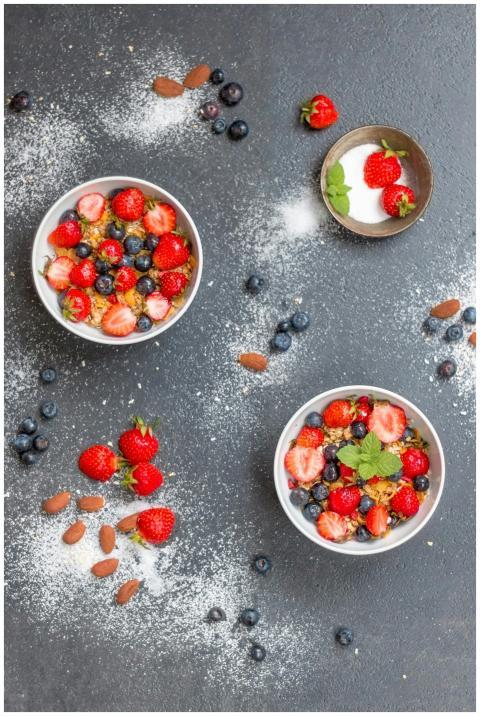 Top view of bowls filled with cereal, strawberries