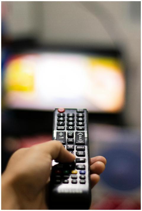 Close-up of a hand holding a remote control, watch