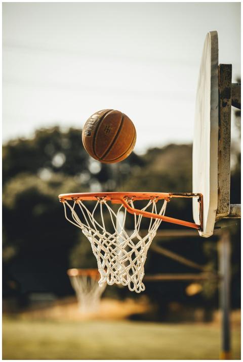 A basketball approaches a hoop on an outdoor court