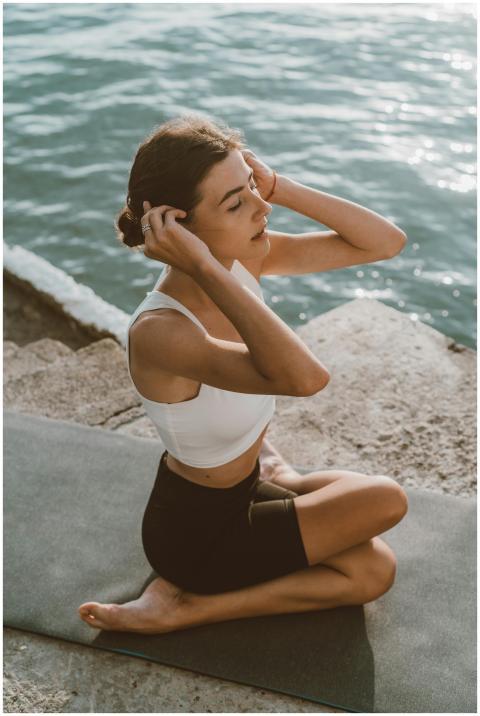 Calm and serene woman meditating by the ocean on a