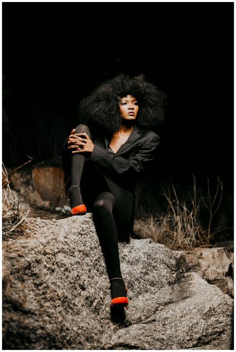 Elegant African model in black outfit poses confid