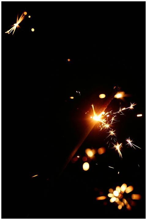 A close-up of a sparkling firework sparkler illumi