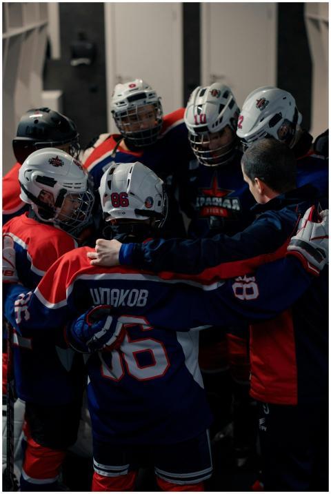 A youth hockey team gathers in a circle for a moti