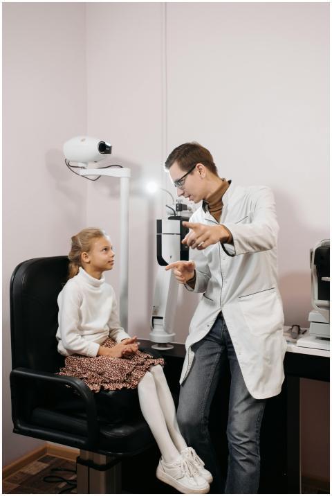 Eye doctor examining a young girl in a clinic sett