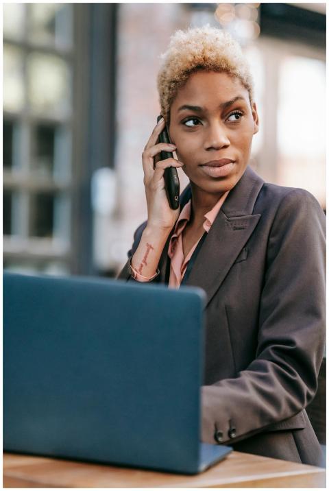 Professional businesswoman in a suit using a phone