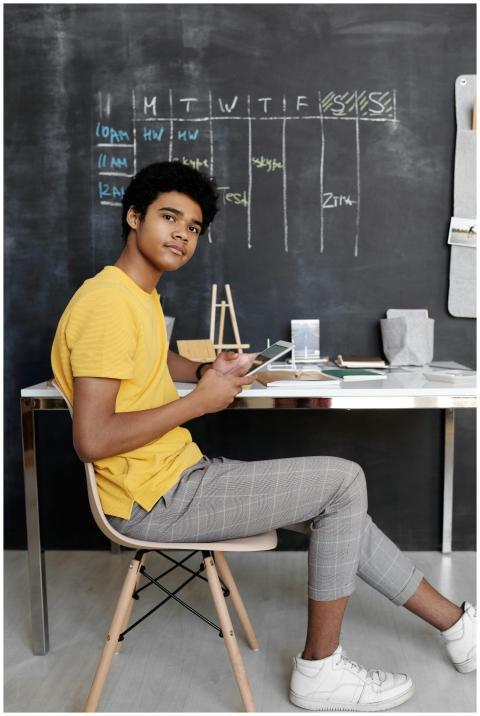 A teenager using a tablet for study in a modern cl