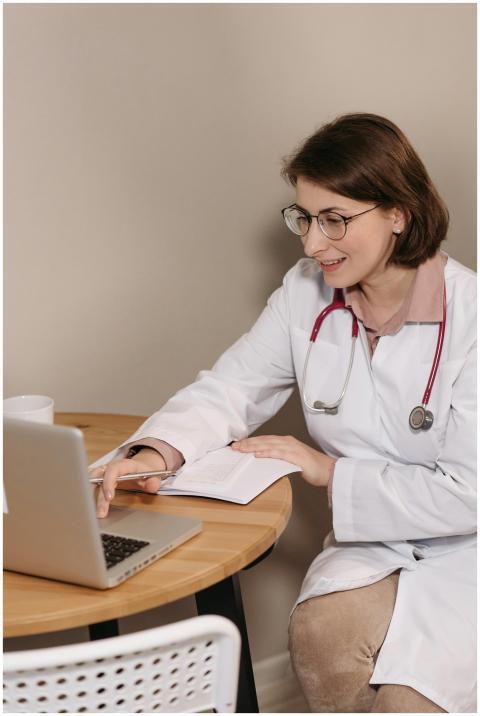 Female doctor using a laptop while sitting at a de