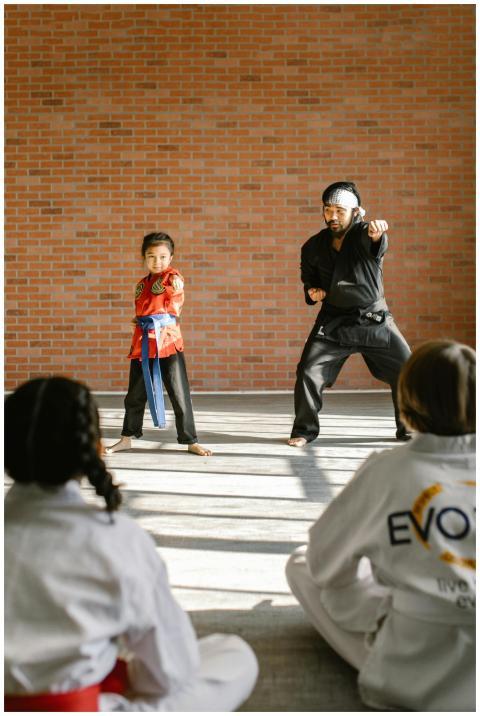A karate instructor teaching a young student marti