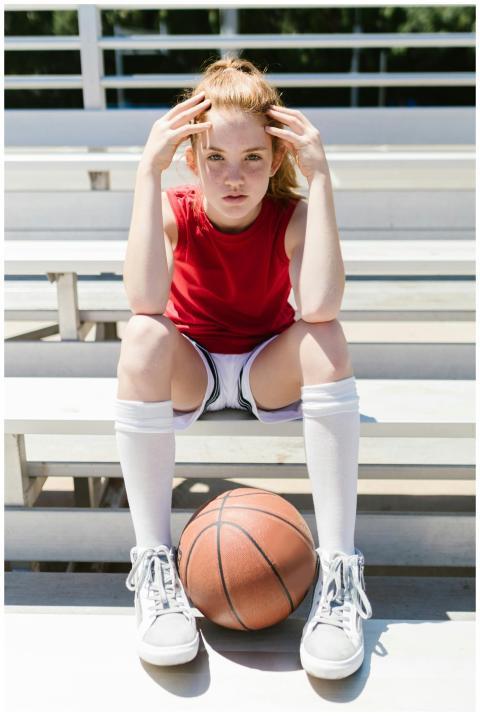 Confident teenager girl in sportswear sitting with