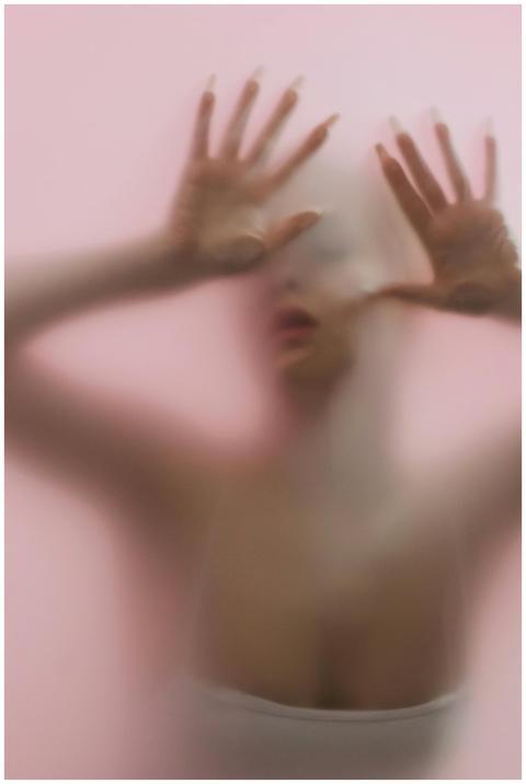 Blurred silhouette of a woman behind frosted glass