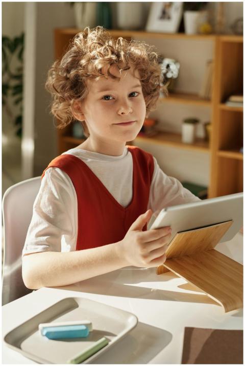 Curly-haired girl using tablet for online learning