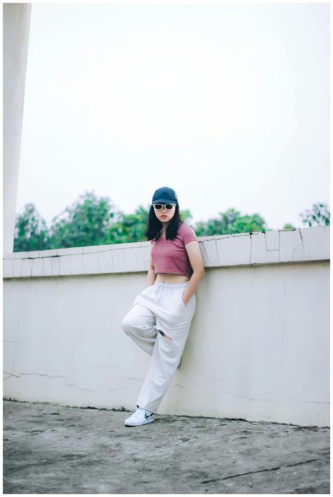 Fashionable woman poses in a crop top and trousers