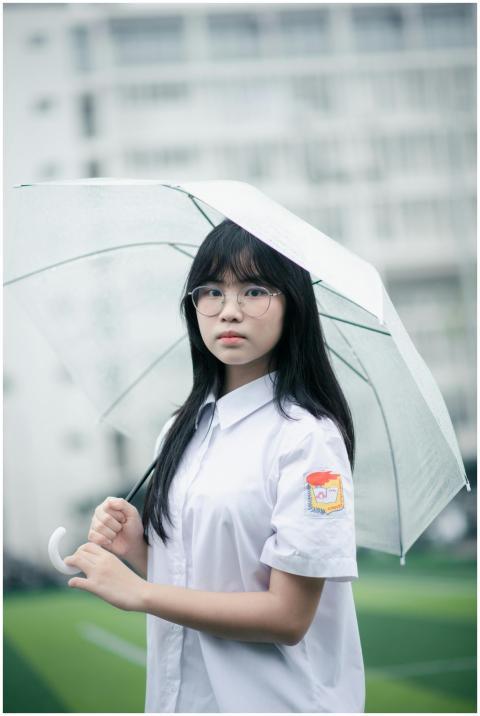 Young girl in school uniform holding a transparent