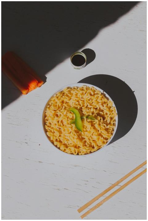 Top view of macaroni with bell pepper slice on a w