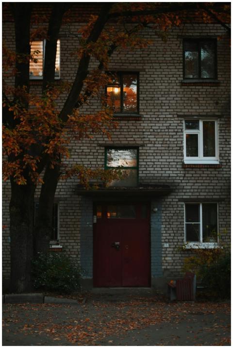 Brick apartment building with autumn foliage and e