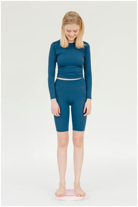 Young woman in blue sportswear smiling while stand