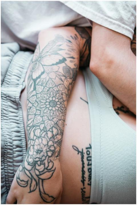 Detailed close-up of tattooed arms in an intimate