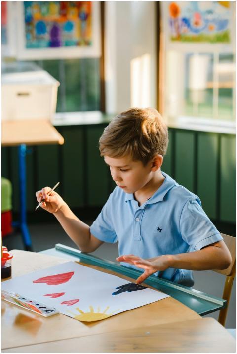 Young boy painting indoors, fostering creativity a