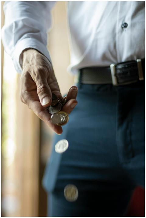 A person dropping coins from their hand emphasizes