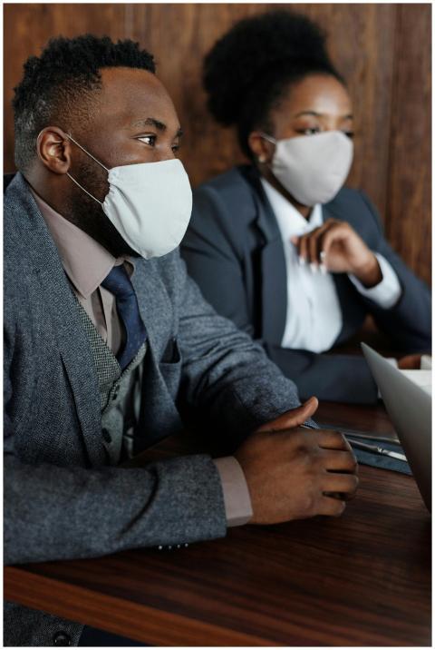 Business professionals wearing masks in a meeting,