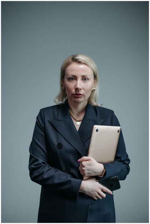 Professional businesswoman in a black blazer holdi