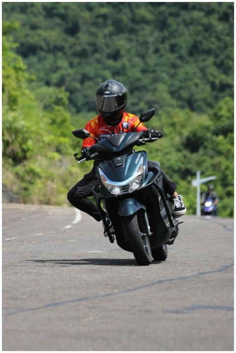 A motorcyclist navigates a curvy mountain road, sh
