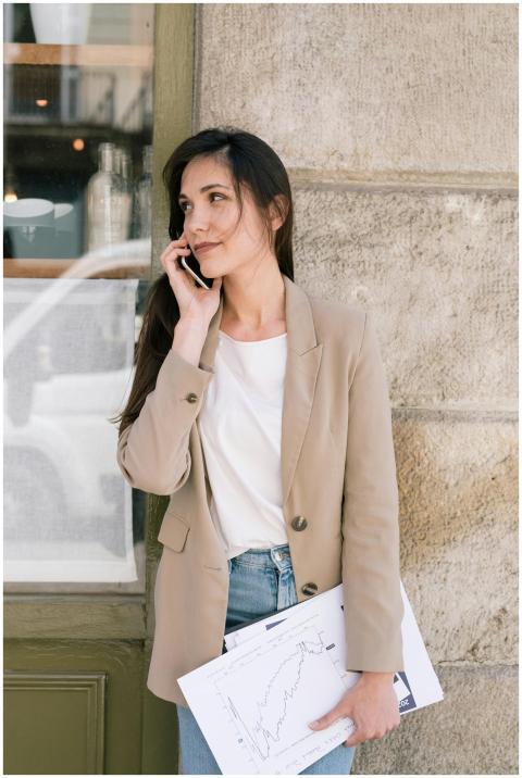 Businesswoman in casual blazer talking on phone ou