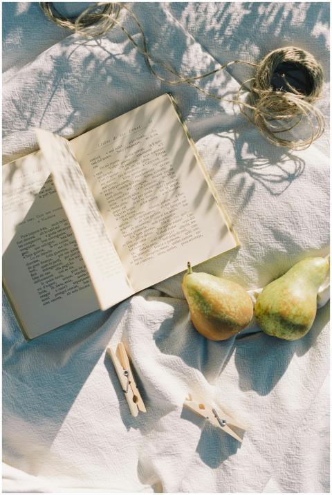 A rustic flat lay featuring an open book, pears, c