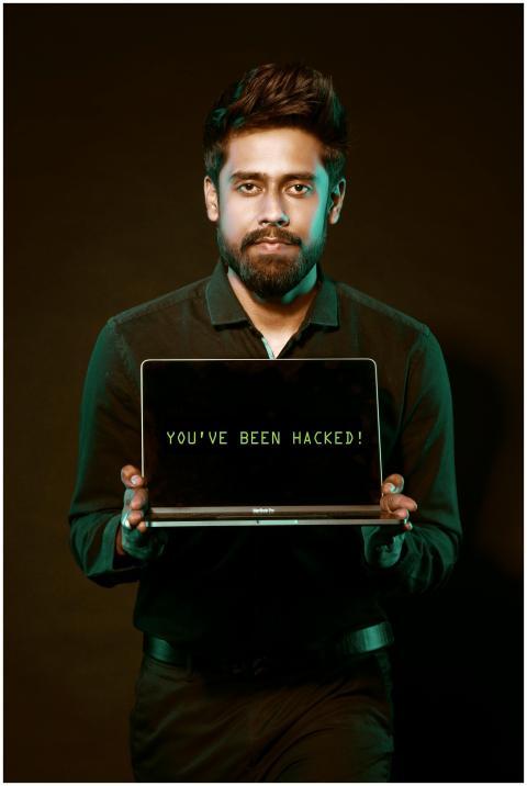 A man showing a laptop with a 'You've been hacked'