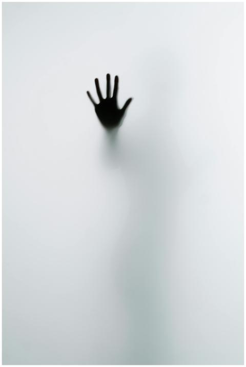 A mysterious hand silhouette pressed against frost