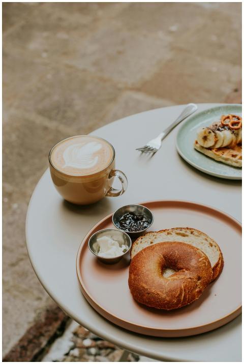 A cozy cafe breakfast scene featuring a bagel with