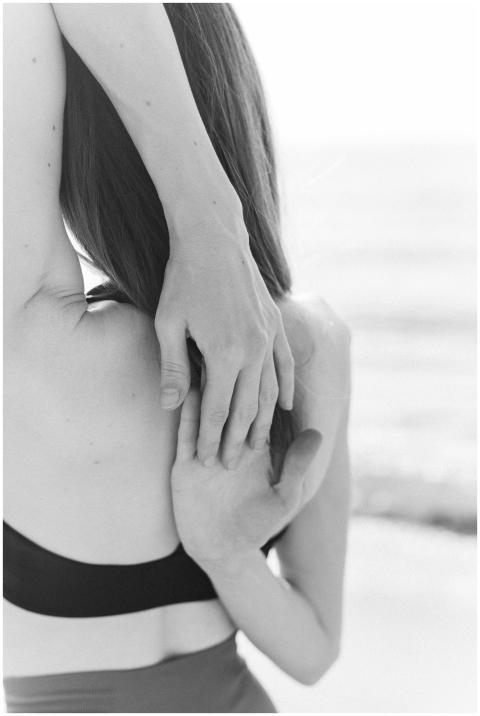 A woman stretching her arms while facing the sea i