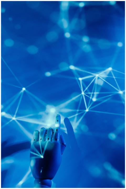 Futuristic robotic hand touching a digital network