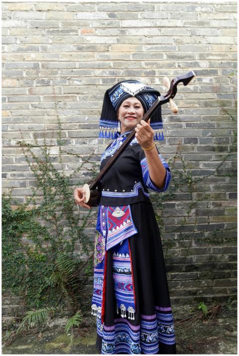 Zhuang woman in vibrant traditional dress holding