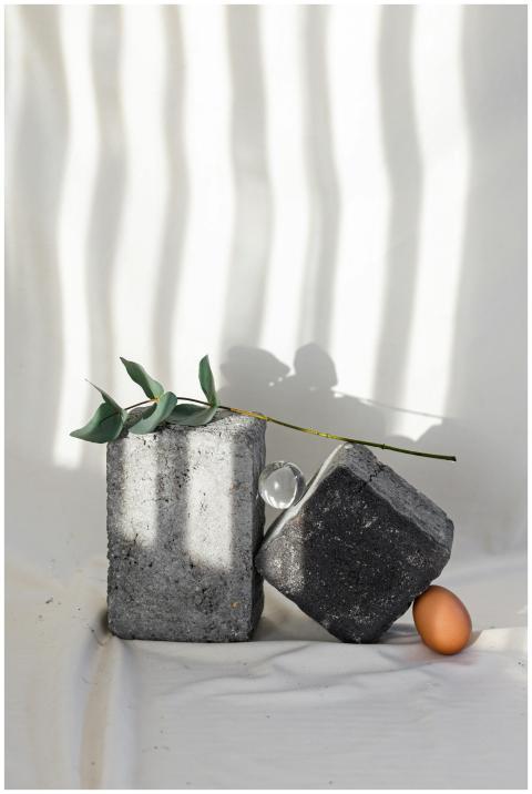 Minimalist arrangement of stones, an egg, and leav