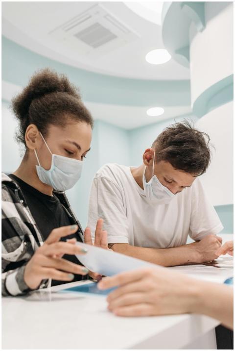 A couple wearing face masks reads documents at a c