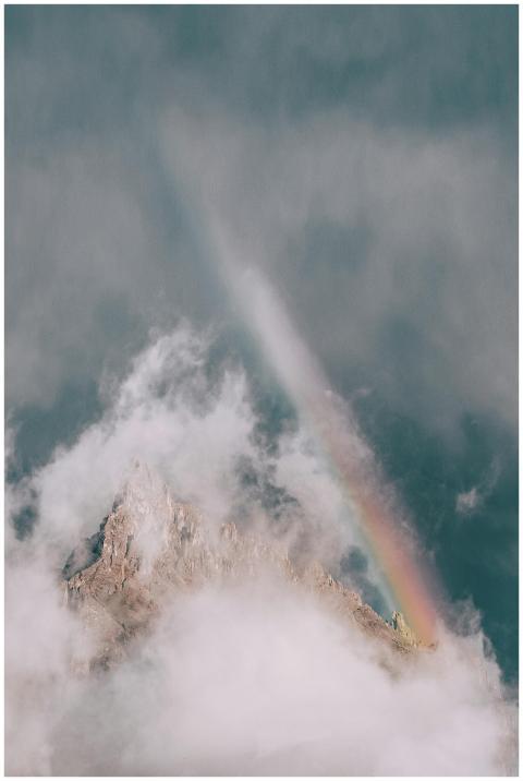 A serene mountain peak enveloped in fog with a vib