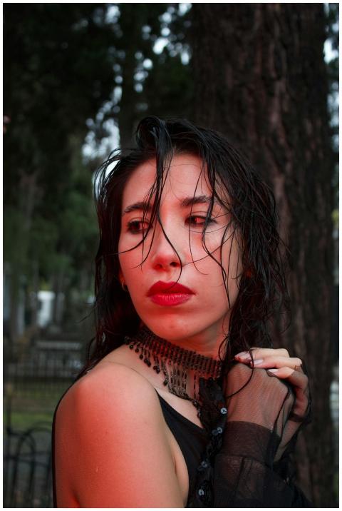 A striking portrait of a woman with wet hair and g